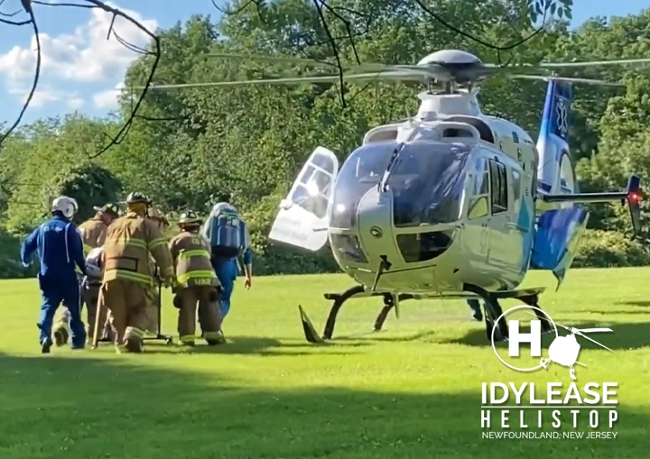 First responders moving a stretcher toward an air-medical helicopter at Idylease Helistop